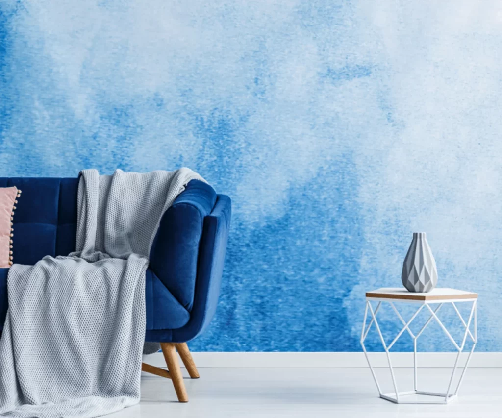 Painter finishing a blue painted wall in a Dubai apartment